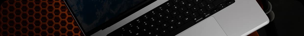 Laptop ucięty w połowie jako druga część zdjęcia przedstajajcego artytstyczne ułożenie urządzenia do tworzenia stron internetowych dla firm